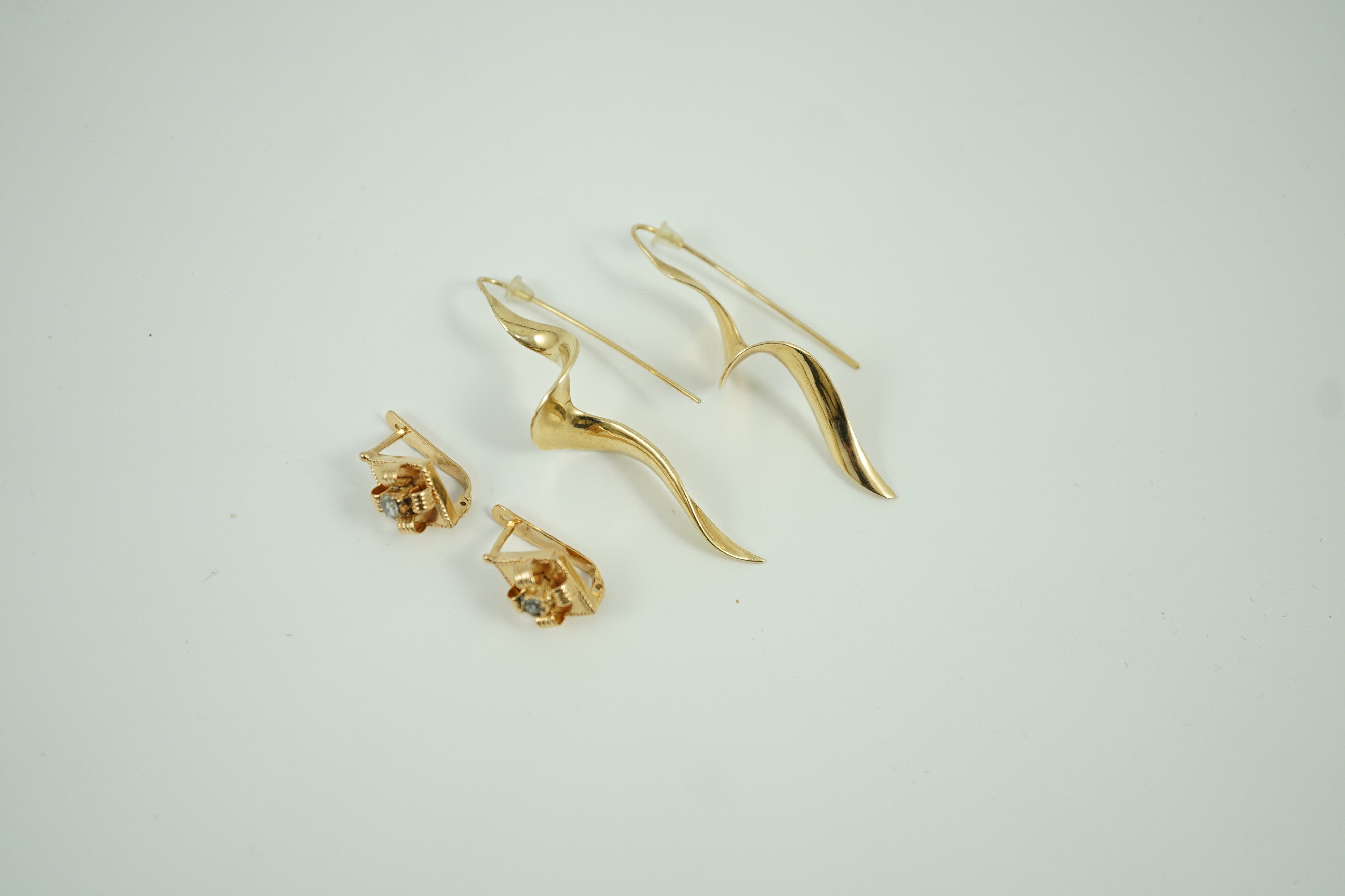 A modern pair of 14k spiral earrings, 50mm, 6.4 grams and a part of yellow metal and solitaire rose cut diamond set earrings, gross 4.2 grams.
